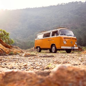 Classic VW Van Parked On Rocky Terrain With Mountains In Alegría, El Salvador.