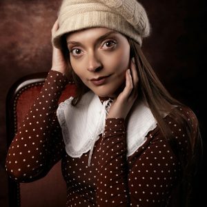 Charming Woman In Polka Dot Outfit And Knit Hat, Captured In A Vintage Style Portrait.