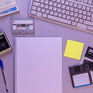 An Arrangement Of Retro Office Supplies Featuring Vintage Electronics And Media On A Desk.