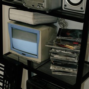 Retro Electronics Display With Vintage Stereo, CRT Monitor, And CDs On Shelves.
