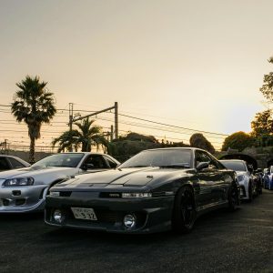 Vintage Japanese Cars Parked During A Sunset Meet In Tokyo, Showcasing Iconic Automotive Design.