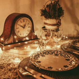 Cozy Vintage Dining Setup With Antique Clock, Tableware, And Warm Lighting, Perfect For Elegant Dinner Scenes.