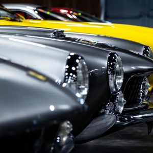 A Close Up View Of Classic Vintage Cars Lined Up In An Indoor Showroom.