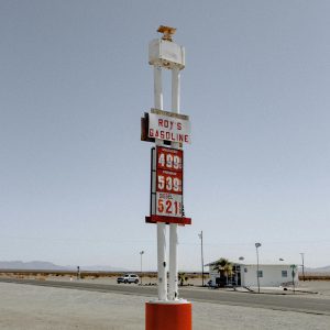 Vintage Gas Station Sign In A Desert Landscape Under A Clear Sky.