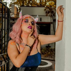 A Creative And Colorful Portrait Showcasing Surreal Makeup And Fantasy Elements In An Outdoor Setting.