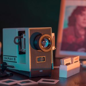 A Nostalgic Close Up Of A Vintage Slide Projector Setup With A Photo Frame, Evoking Retro Vibes.