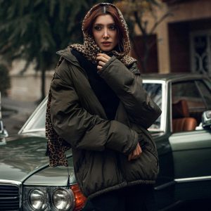 Fashionable Woman In Winter Coat Poses Next To A Vintage Car In An Urban Setting.