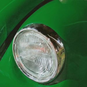 Detailed View Of A Classic Volkswagen Beetle's Green Fender And Headlight.