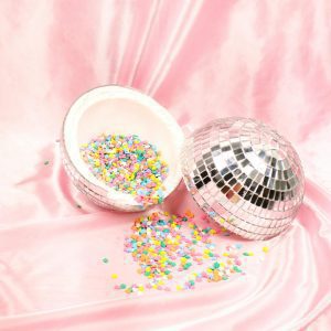 Vibrant Confetti Spills From A Disco Ball On A Soft Pink Satin Backdrop.