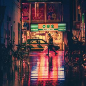 Atmospheric Night Cityscape Featuring Neon Lights, Wet Streets, And Urban Life In Tokyo.