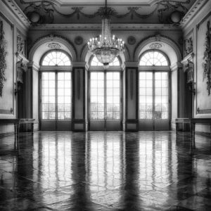 Black And White Photo Of A Baroque Interior With A Chandelier And Large Windows.