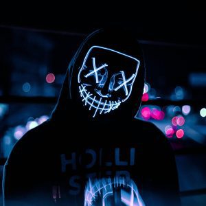 A Person Wearing A Glowing Neon Mask With A Hoodie In An Urban Night Setting, Dominican Republic.