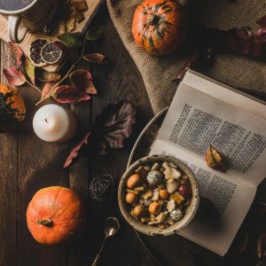 Warm And Rustic Autumn Scene With Pumpkins, Tea, And Dried Leaves On A Wooden Table.