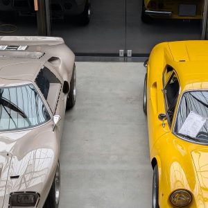 A Vintage Car And A Yellow Sports Car Photographed Indoors At A Classic Car Showroom In Berlin.