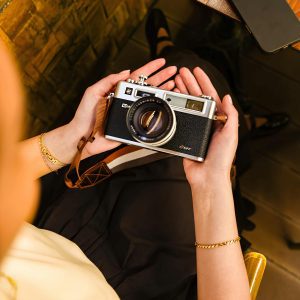 Person Holding Vintage Camera, Capturing Creative Moments Indoors.