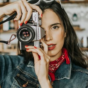 Stylish Woman Posing With A Vintage Camera Indoors, Showcasing Fashion And Creativity.