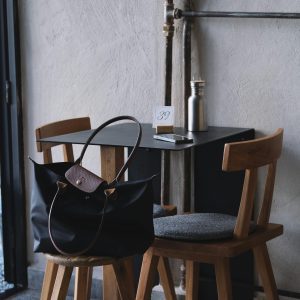 A Fashionable Tote Bag On A Chair In A Cozy Café Corner, Perfect For Lifestyle Themes.