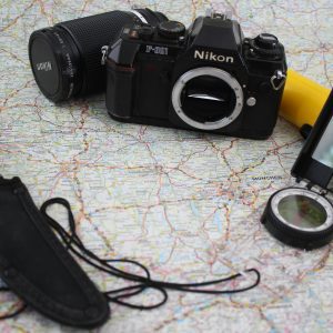 A Collection Of Vintage Adventure Gear Featuring A Camera, Compass, And Knife On A Map, Ready For Exploration.
