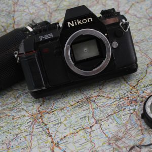 Explore Travel And Photography With A Classic Camera And Compass On A Detailed World Map.