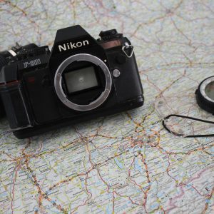 Explore With A Vintage Nikon Camera On A Detailed Travel Map, Perfect For Adventure Enthusiasts.