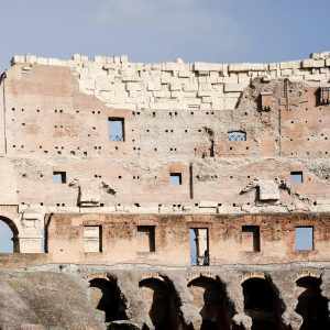 Close Up View Of The Colosseum In Rome, Showcasing Ancient Roman Architecture Against A Clear Sky.