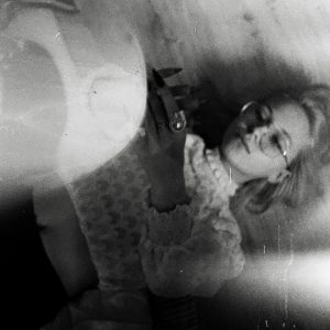 Grainy Grayscale Photo Of A Woman Lying Down, Evoking A Vintage Feel.