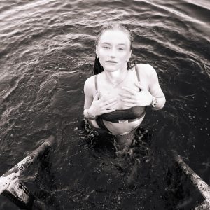 A Serene Black And White Portrait Of A Woman Climbing A Pool Ladder From Water.