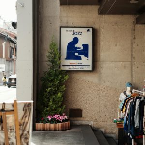 Charming Kyoto Street Corner Featuring A Jazz Club Sign, Clothing Rack, And Potted Plants.