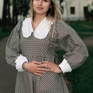 Portrait Of A Young Woman In A Vintage Dress Standing Outdoors With Soft Natural Lighting.