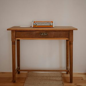 A Vintage Wooden Desk With A Classic Typewriter, Perfect For Retro And Nostalgic Decor Themes.