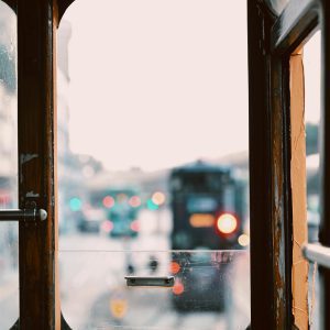 View From Inside A Vintage Tram Window Showing Blurred City Traffic Outside, Evoking A Nostalgic Urban Vibe.