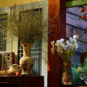 A Cozy Indoor Setting With Vintage TV, Floral Vases, And Ambient Lighting.