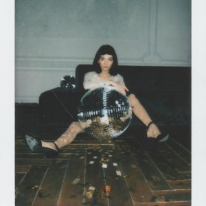 Fashionable Woman Posing With A Disco Ball Indoors. Vintage Polaroid Style.