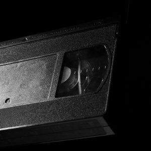 High Contrast Close Up Of A Retro VHS Tape Against A Dark Background.