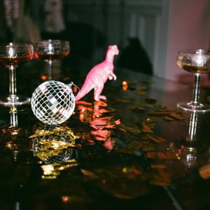A Celebration Scene Featuring Glasses, Disco Ball, And Confetti, Creating A Festive Party Atmosphere.