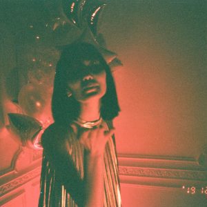 Stylish Woman In Glamorous Setting With Balloons, Captured In Moody Vintage Light.