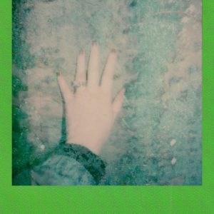 Retro Style Instant Photo Showing Hand Against A Textured Dusty Surface With Green Border.