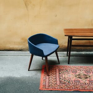 Minimalist Interior With Vintage Blue Chair, Persian Rug, And Simple Wooden Table.