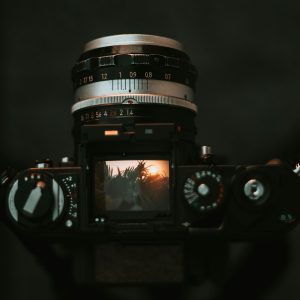 Artistic Close Up Of A Vintage Camera With Landscape Reflection In The Viewfinder, Creating A Nostalgic Mood.