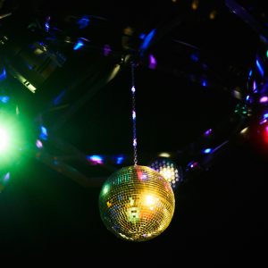 A Vibrant Disco Ball Reflecting Multicolored Lights In A Lively Club Setting, Perfect For Party Themes.
