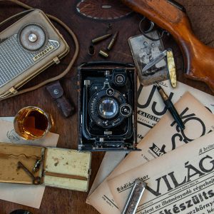 A Collection Of Vintage Items Including A Camera, Radio, And Newspaper Creates An Old Fashioned Vibe.