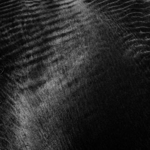Detailed Close Up Of A Black Sand Texture With Smooth And Patterned Ripples.