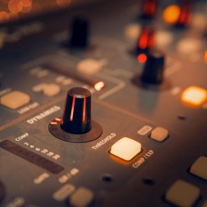 A Detailed View Of An Audio Mixer With Glowing Knobs, Perfect For Music Production Themes.