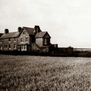Black And White Vintage Photo Of An Old Farmhouse In Weybourne, Surrounded By Fields.