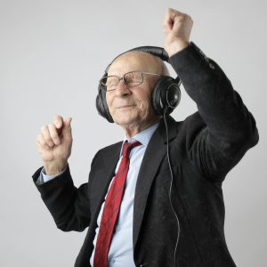 Senior Man Enjoying Music With Headphones, Expressing Happiness And Energy.