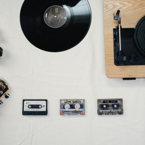 Flat Lay Of Guitar, Vinyl, Cassettes, And Headphones Showcasing A Classic Music Collection.