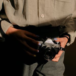 Close Up Shot Of A Person Holding A Vintage Film Camera, Casting Intriguing Shadows.