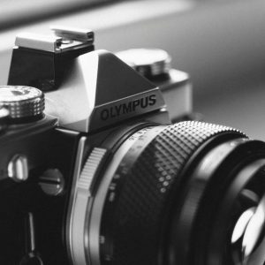 Close Up Of A Vintage Olympus Camera Lens In Monochrome, Showcasing Intricate Details.
