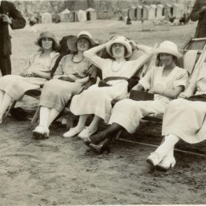 A Nostalgic Black And White Photo Showing Women Relaxing On A Beach, Embodying Vintage Leisure.