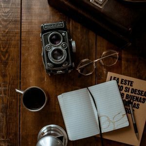 A Vintage Rollei Camera With Coffee, Glasses, And Open Notebook On A Wooden Surface, Ideal For Retro Themes.